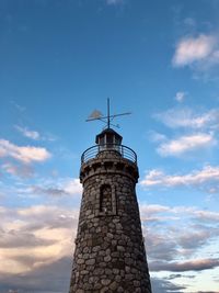 Lighthouse by sea against sky