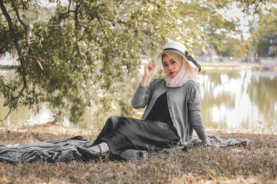 Portrait of young woman sitting on field