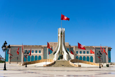 Low angle view of flag on building against blue sky