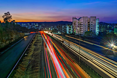 High angle view of light trails on road against sky during sunset