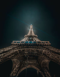 Low angle view of illuminated tower against sky at night