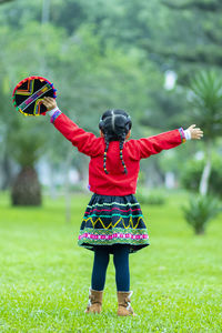 Rear view of girl standing on field