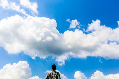 Rear view of man against blue sky
