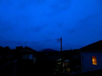 Silhouette houses against sky at dusk