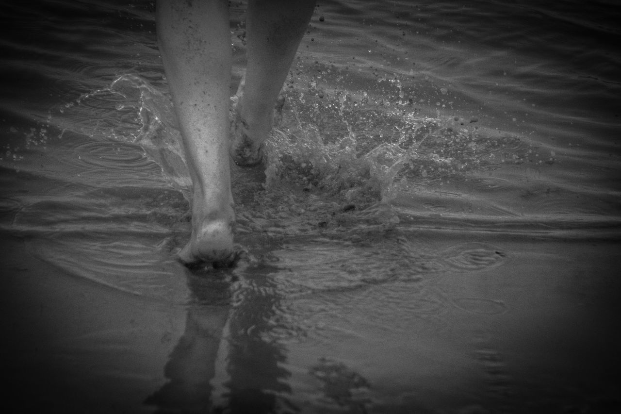 LOW SECTION OF BARE FEET ON WET LAND