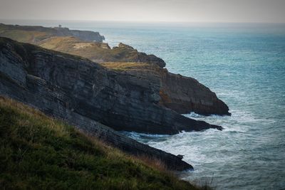 Rock formations on sea shore against sky