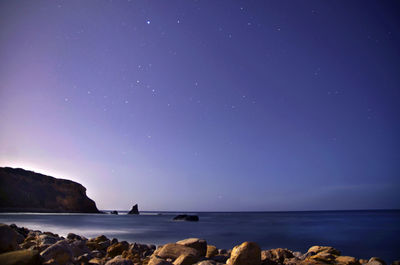 Scenic view of sea against star field at dusk