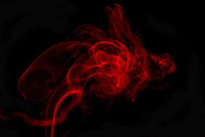 Close-up of red smoke against black background