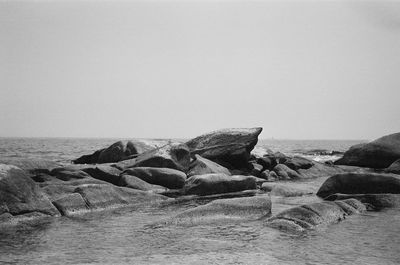 Rocks on shore against clear sky