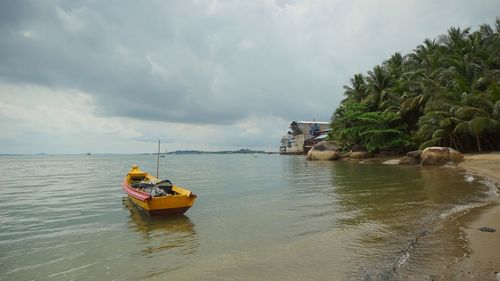 Boat moored on sea against sky