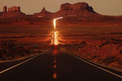 Road amidst mountains against sky during sunset