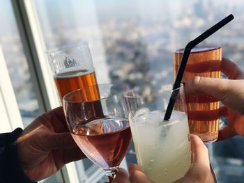 Cropped hands of friends toasting beer glasses