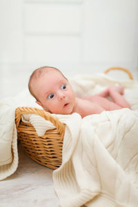 Portrait of cute baby lying on bed at home
