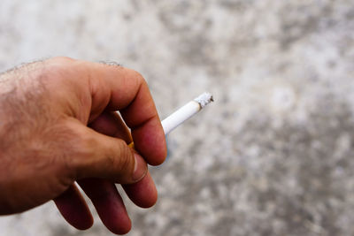 Close-up of hand holding cigarette