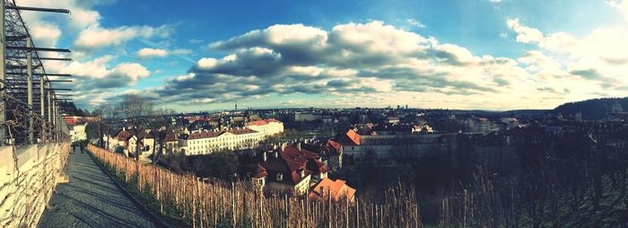 View of cityscape against cloudy sky