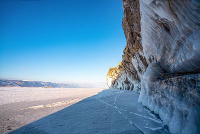Icicles on snow covered mountain against clear sky