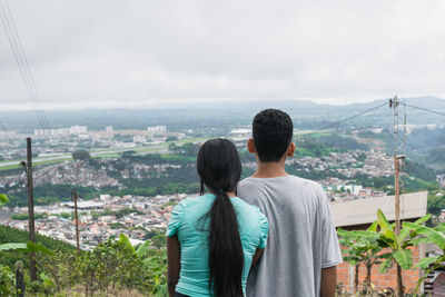 Young latin couple, country people looking towards the city of pereira-colombia. university students
