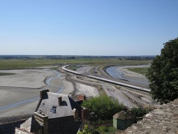 High angle view of road amidst field against clear sky