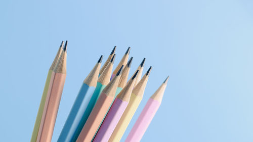 Close-up of colored pencils against clear blue sky