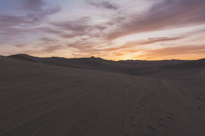 Tire tracks and footprints on sand in desert