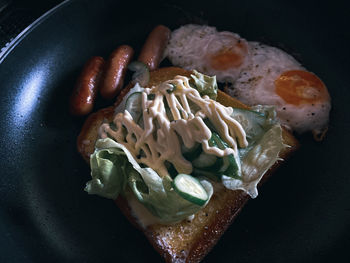 High angle view of breakfast in frying pan - fried egg / bread /salad /sausage