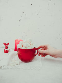 Cropped hand of woman holding cup on table