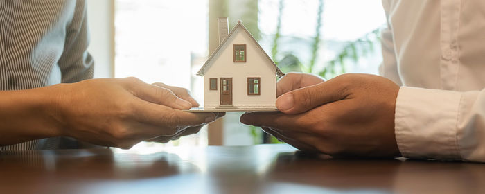 Close-up of man holding toy against house in building