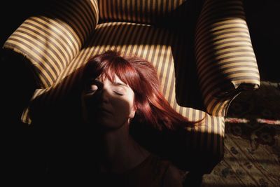 High angle view of woman sleeping on armchair at home