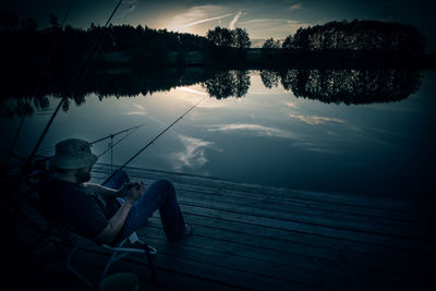 Reflection of man sitting in water