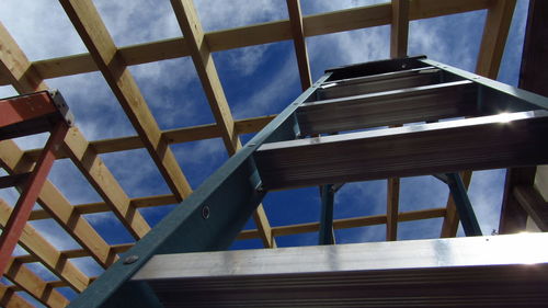 Low angle view of ladder and framing against sky