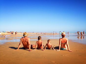Rear view of family sitting at beach