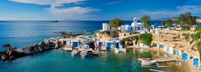 Boats moored in sea against blue sky