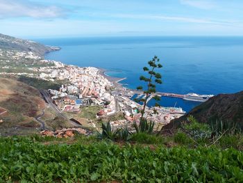 High angle view of townscape by sea against sky