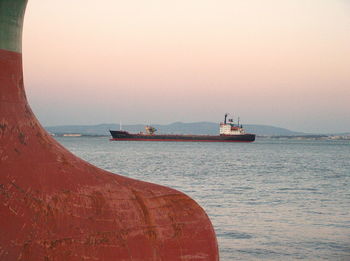 Boat sailing in sea at sunset