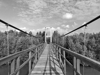 Bridge walking on footbridge against sky