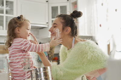 Mother and daughter preparing food in kitchen at home