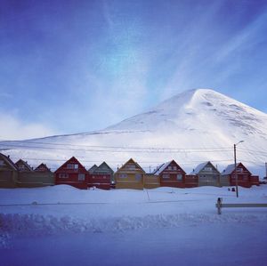 Houses on snowcapped mountain against sky