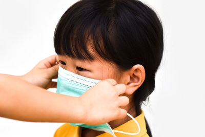 Close-up of girl holding gift against white background