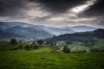 Scenic view of village and mountains against sky