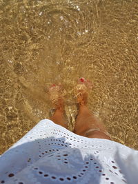 Low section of woman standing on beach