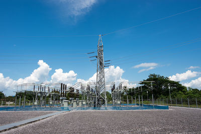 Low angle view of electricity pylon against blue sky