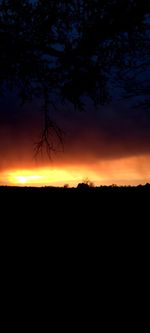 Scenic view of silhouette landscape against orange sky