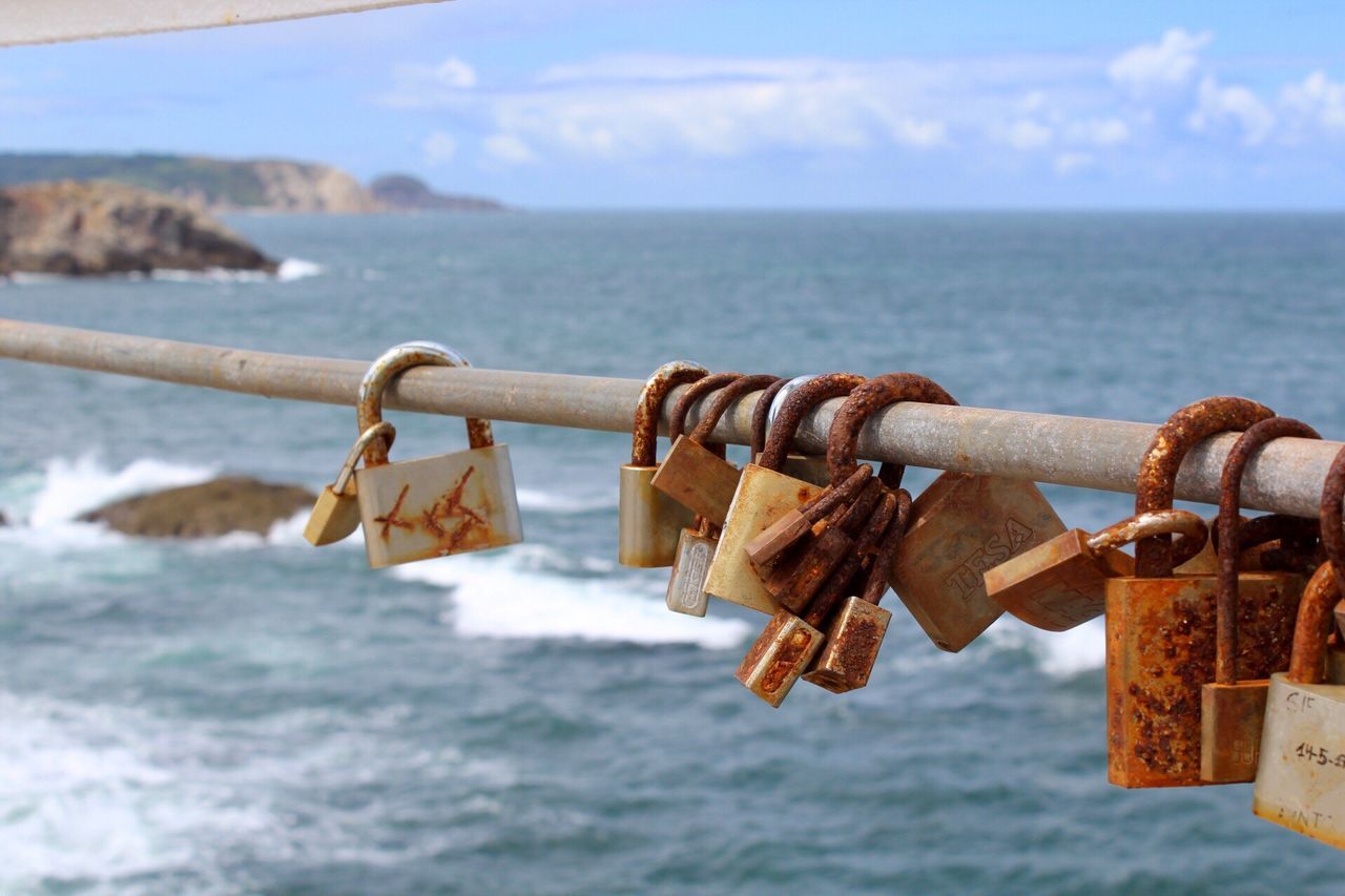 padlock, lock, love lock, security, safety, hanging, protection, sea, metal, water, railing, hope, horizon over water, rusty, luck, focus on foreground, love, hope - concept, safe, chain, sky, outdoors, no people, close-up, day, nature