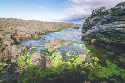 Scenic view of rocks and sea against sky