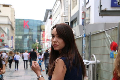 Portrait of young woman on city street