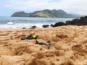 Close-up of flip-flops on sand