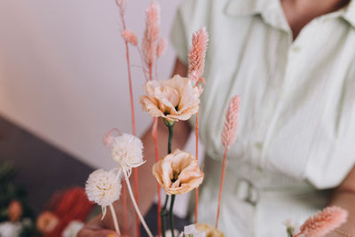 Midsection of woman holding flowers