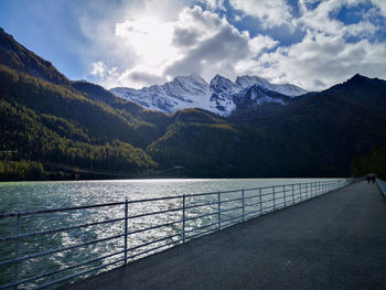 Scenic view of lake by mountains against sky