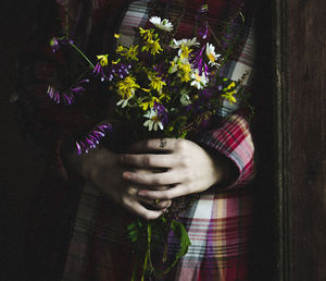 Midsection of woman holding bouquet