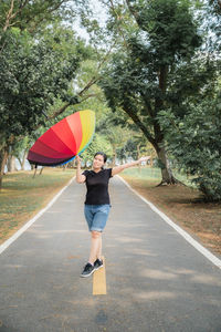 Rear view of man with umbrella on road